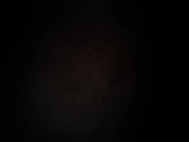 Karanlık gökyüzünde dolunay ve siyah bir arka plan.