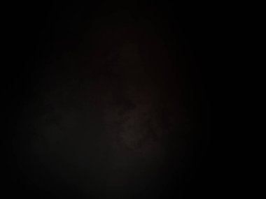 Siyah gömlekli bir adam elinde kamera tutuyor.