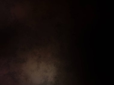 Takım elbiseli ve kravatlı bir adam karanlık bir arka planın önünde duruyor.