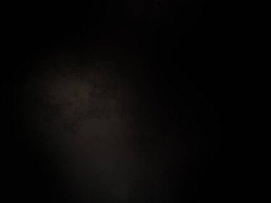 Karanlıkta duran takım elbiseli ve kravatlı bir adam.