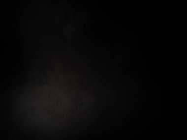 Karanlıkta duran takım elbiseli ve kravatlı bir adam.