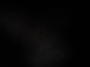 Siyah bir arka planın önünde duran takım elbiseli ve kravatlı bir adam.