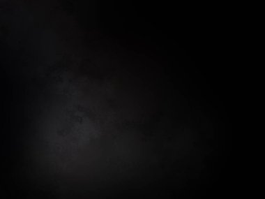 Siyah bir arka planın önünde duran takım elbiseli ve kravatlı bir adam.