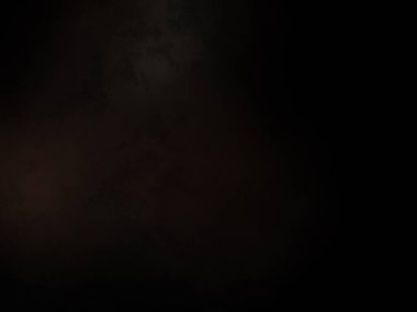 Karanlıkta duran takım elbiseli ve kravatlı bir adam.