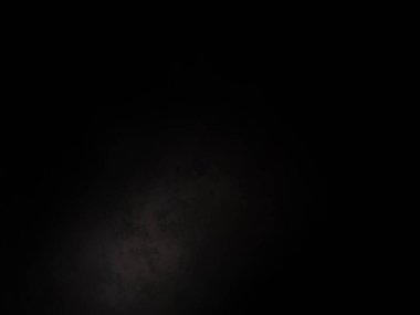 Siyah gömlekli bir adam elinde kamera tutuyor.