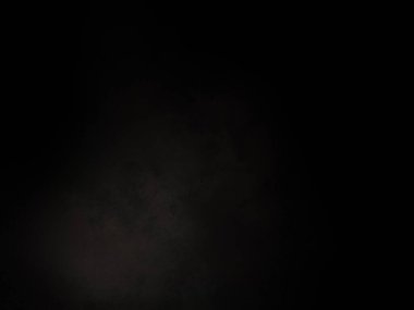 Siyah gömlekli bir adam elinde kamera tutuyor.