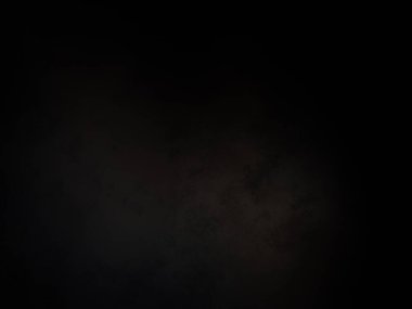 Siyah bir arka planın önünde duran takım elbiseli ve kravatlı bir adam.