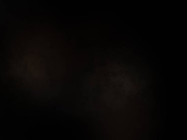 Siyah bir arka planın önünde duran takım elbiseli ve kravatlı bir adam.