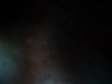 Takım elbiseli ve kravatlı bir adam karanlık bir arka planın önünde duruyor.