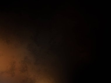 Karanlık bir yüzeyde kaykay süren bir insan.