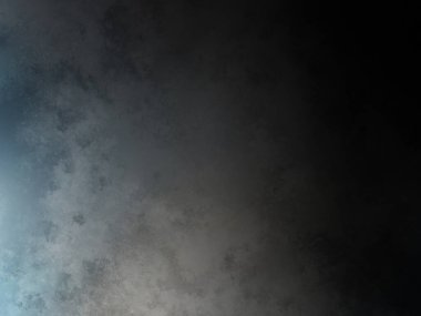 Takım elbiseli ve kravatlı bir adam karanlık bir arka planın önünde duruyor.