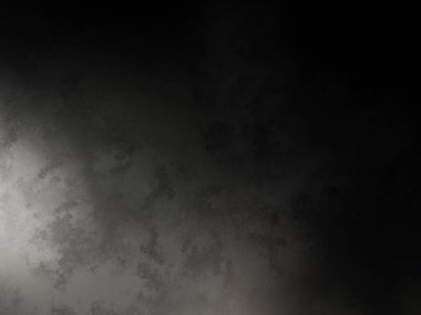 Karanlık bir yüzeyde kaykay süren bir adam.