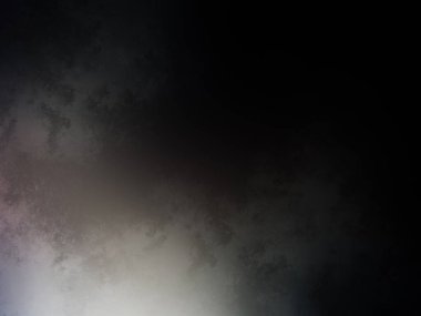 Siyah gömlekli bir adam tenis raketi tutuyor.