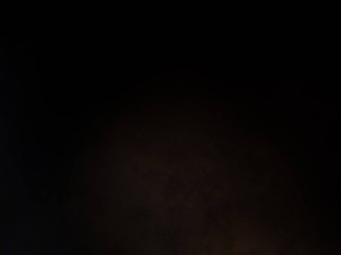 Takım elbiseli ve kravatlı bir adam mikrofonun önünde duruyor.