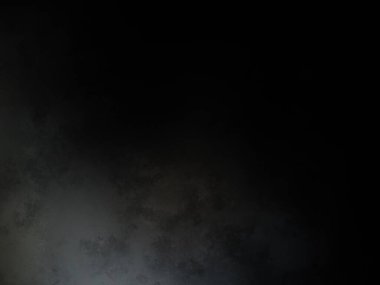 Siyah bir arka planın önünde duran takım elbiseli ve kravatlı bir adam.