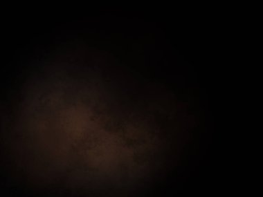 Siyah bir arka planın önünde duran takım elbiseli ve kravatlı bir adam.