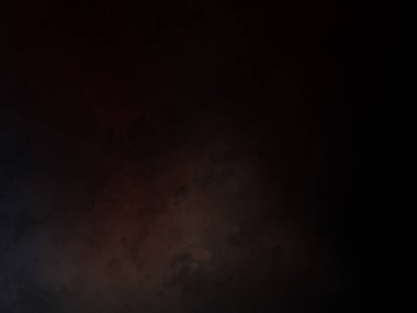 Takım elbiseli ve kravatlı bir adam karanlık bir arka planın önünde duruyor.