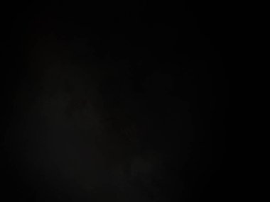 Siyah gömlekli bir adam elinde kamera tutuyor.