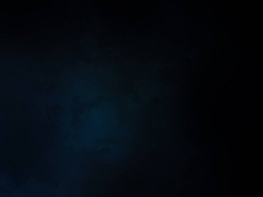 Siyah gömlekli bir adam tenis raketi tutuyor.