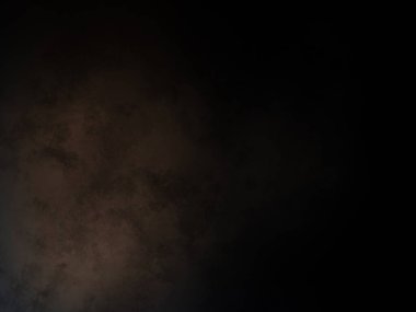 Takım elbiseli ve kravatlı bir adam karanlık bir arka planın önünde duruyor.