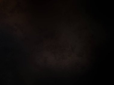 Siyah bir arka planın önünde duran takım elbiseli ve kravatlı bir adam.