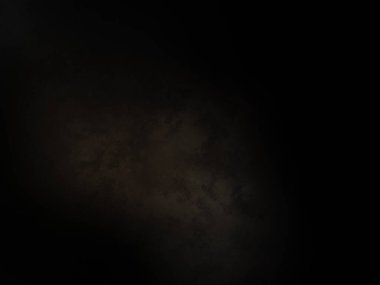 Siyah bir arka planın önünde duran takım elbiseli ve kravatlı bir adam.