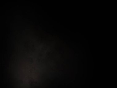 Karanlıkta parlayan bir ışıkla siyah bir arkaplan.