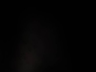 Takım elbiseli ve kravatlı bir adam mikrofonun önünde duruyor.