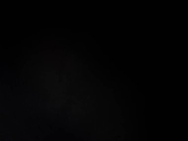 Takım elbiseli ve kravatlı bir adam mikrofonun önünde duruyor.