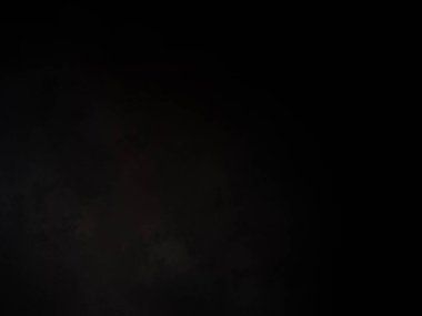 Siyah gömlekli bir adam elinde kamera tutuyor.