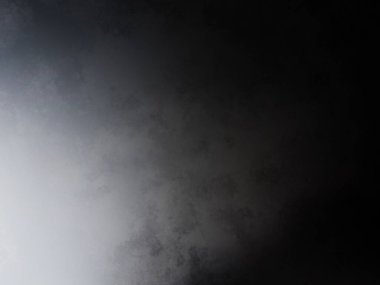 Siyah gömlekli bir adam tenis raketi tutuyor.