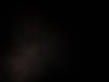 Siyah bir arka planın önünde duran takım elbiseli ve kravatlı bir adam.