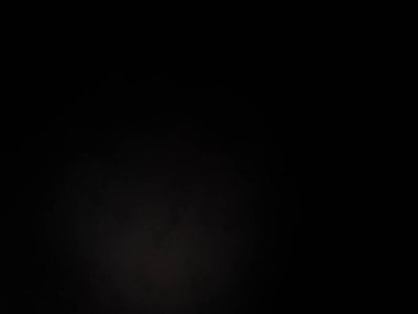 Siyah bir arka planın önünde duran takım elbiseli ve kravatlı bir adam.