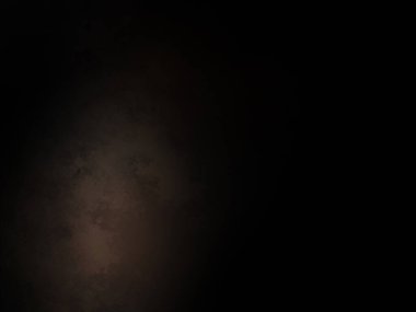 Siyah bir arka planın önünde duran takım elbiseli ve kravatlı bir adam.