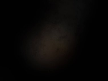 Siyah bir arka planın önünde duran takım elbiseli ve kravatlı bir adam.