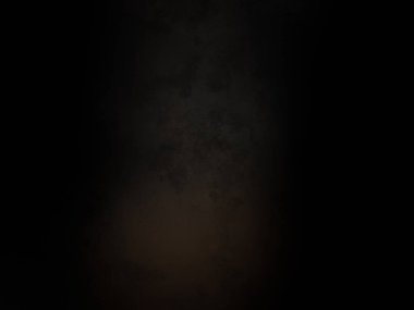 Siyah bir arka planın önünde duran takım elbiseli ve kravatlı bir adam.