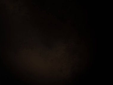 Siyah bir arka planın önünde duran takım elbiseli ve kravatlı bir adam.