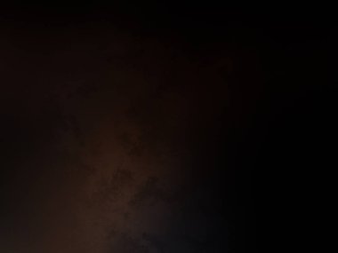 Takım elbiseli ve kravatlı bir adam ateşin önünde duruyor.