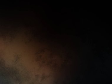 Takım elbiseli ve kravatlı bir adam karanlık bir arka planın önünde duruyor.