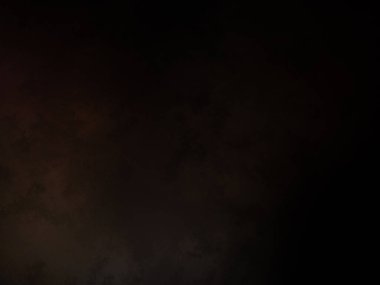 Takım elbiseli ve kravatlı bir adam ateşin önünde duruyor.