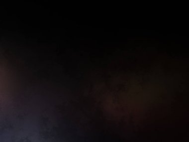 Takım elbiseli ve kravatlı bir adam karanlık bir arka planın önünde duruyor.