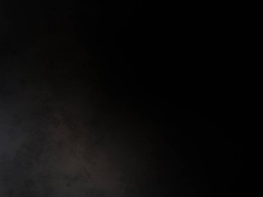 Siyah bir arka planın önünde duran takım elbiseli ve kravatlı bir adam.