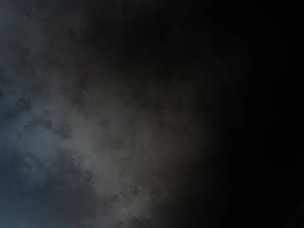 a plane flying through a dark sky with a cloud