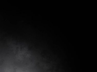 Siyah gömlekli bir adam tenis raketi tutuyor.