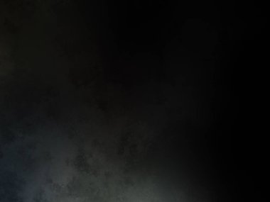 Siyah bir arka planın önünde duran takım elbiseli ve kravatlı bir adam.