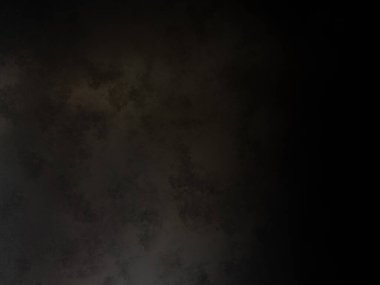 Takım elbiseli ve kravatlı bir adam karanlık bir arka planın önünde duruyor.