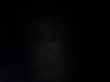 Takım elbiseli ve kravatlı bir adam mikrofonun önünde duruyor.