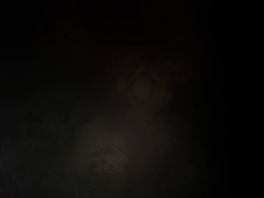 Siyah tişörtlü biri cep telefonu tutuyor.