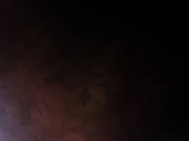 Karanlık bir yüzeyde kaykay süren bir insan.