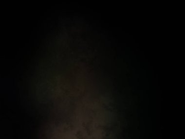 Takım elbiseli ve kravatlı bir adam ateşin önünde duruyor.